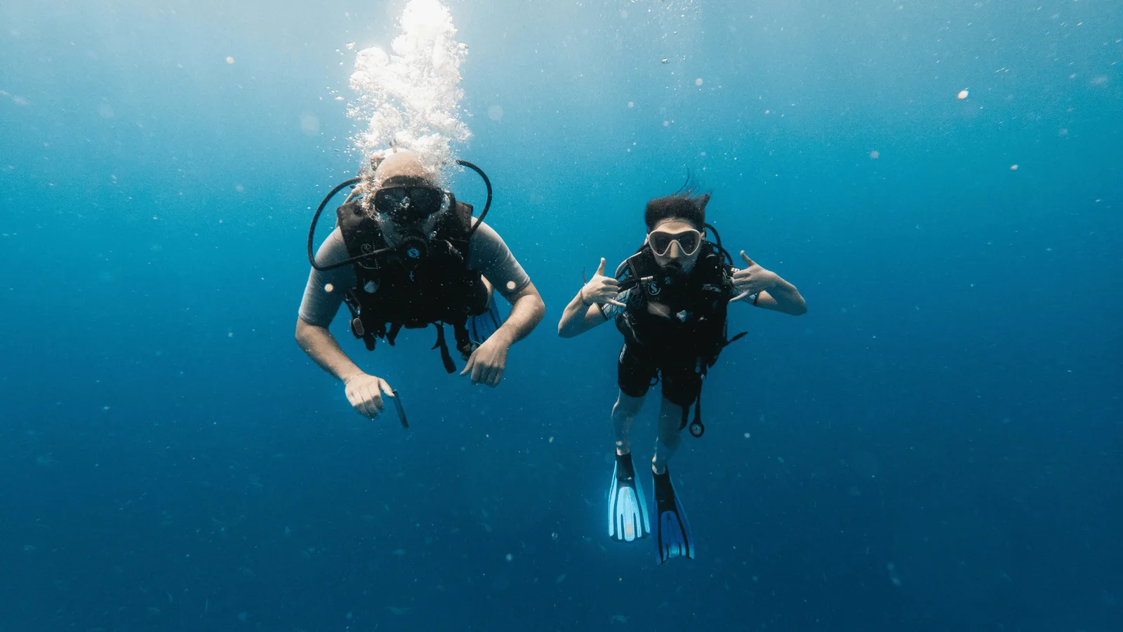 Two divers underwater in clear blue water off Havelock Island