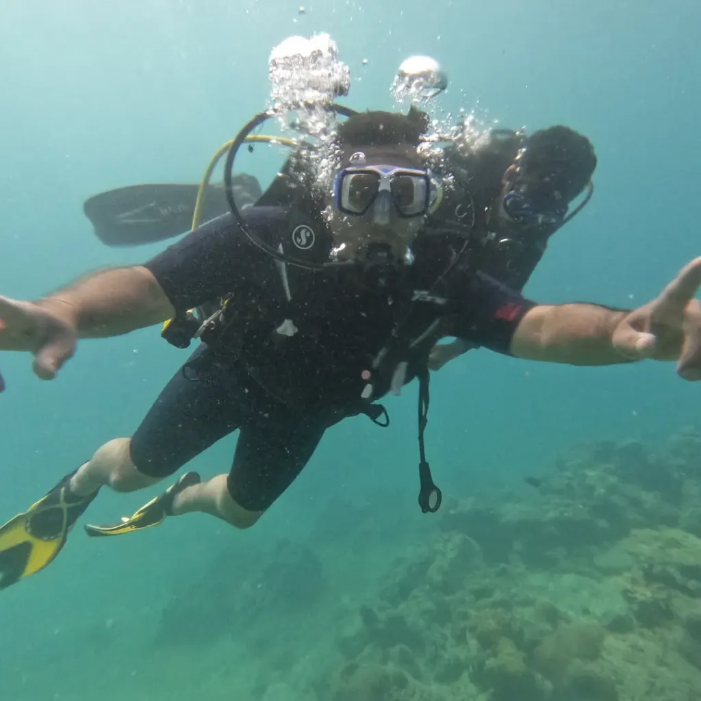 Diver with arms spread flying over the reef, RAID Advanced 35 course in Havelock, Andaman
