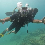 Diver with arms spread flying over the reef, RAID Advanced 35 course in Havelock, Andaman