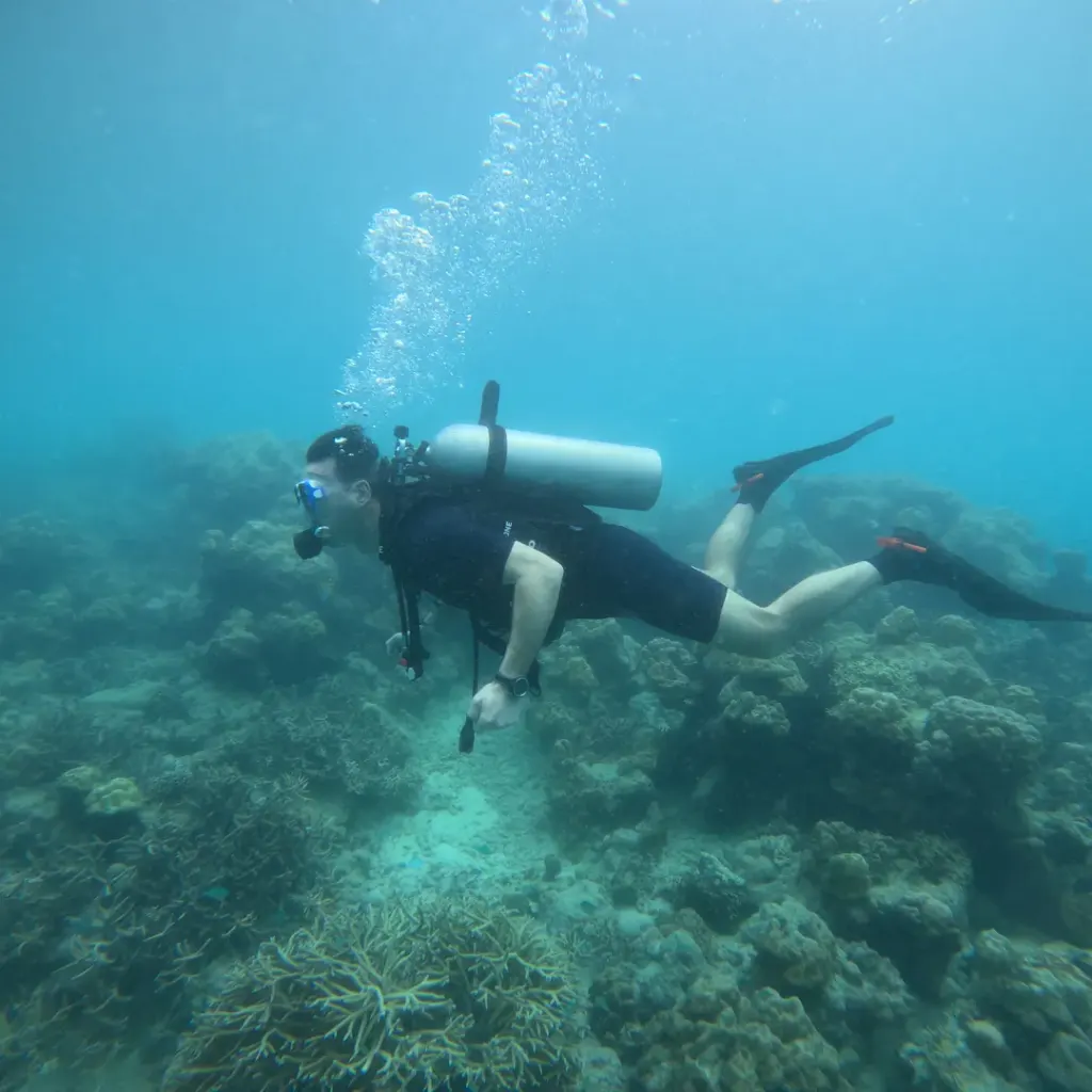 Diver swimming over the reef with bubbles above, RAID Advanced 35 course in Havelock, Andaman