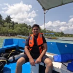 Guest in a life jacket sitting on the dive boat, Red Pillar scuba diving, Havelock Island