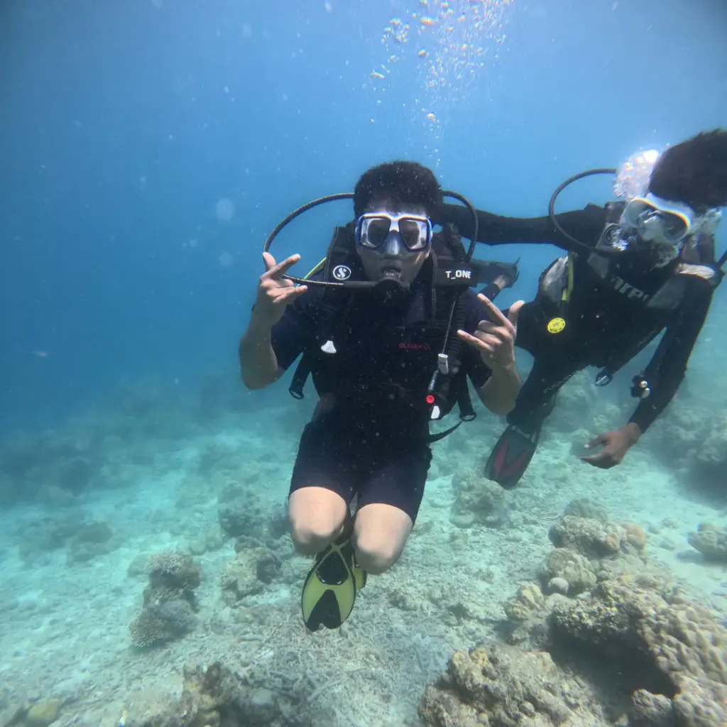 Diver making hand signs above the reef with the instructor beside, Lighthouse scuba diving, Havelock Island