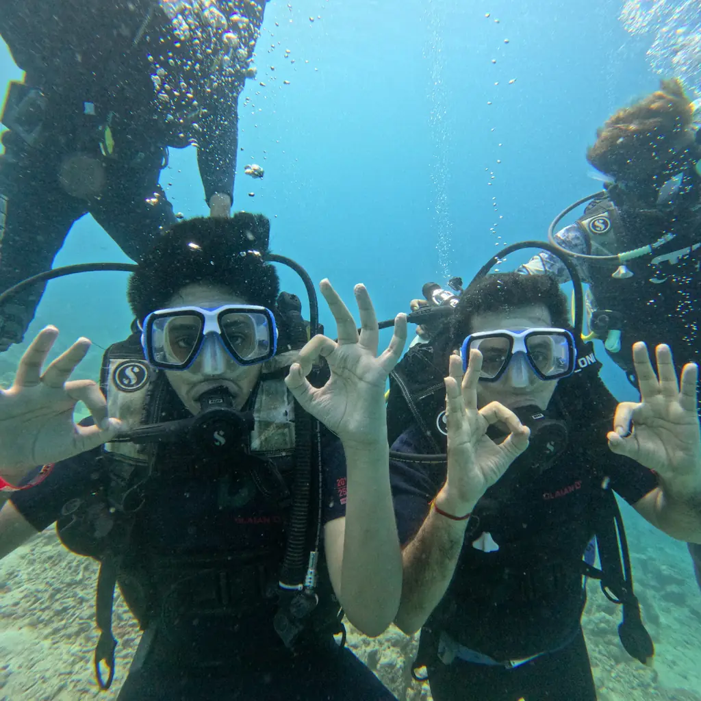 Two divers giving the OK sign underwater in Havelock, Andaman