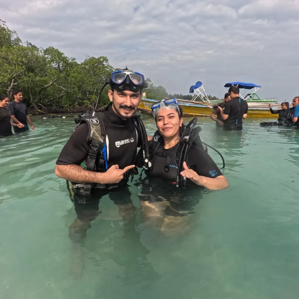 Couple in scuba gear ready for shore scuba diving in Havelock, Andaman