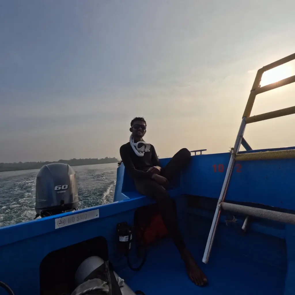 Person sitting at the back of the dive boat in morning light, Nitrox course in Havelock, Andaman