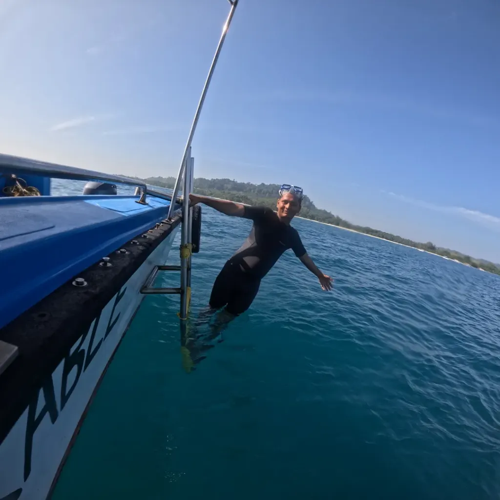 Diver climbing the boat ladder in open water, fun diving in Havelock Island