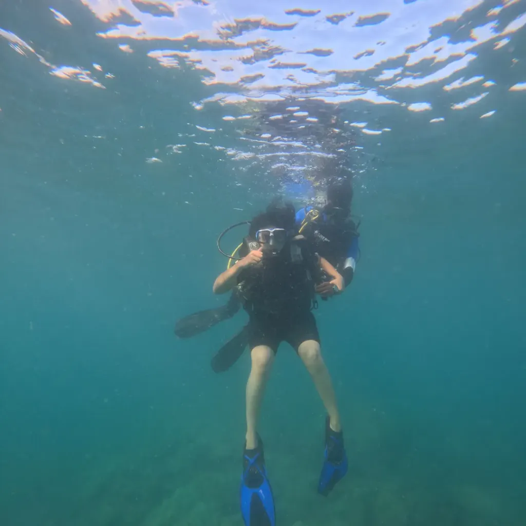 Diver just below the surface with fins out, fun diving in Havelock Island