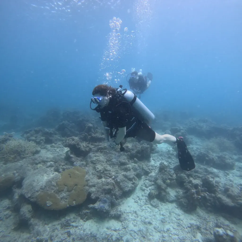 Diver swimming over the reef with another diver behind, fun diving in Havelock Island