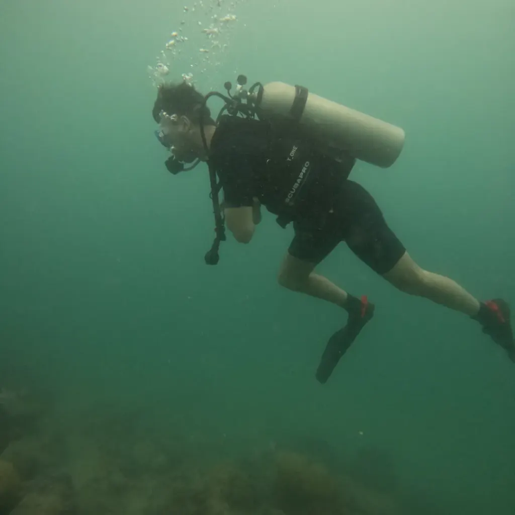 Diver swimming with the tank above the reef, fun diving in Havelock Island