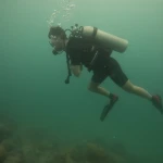Diver swimming with the tank above the reef, fun diving in Havelock Island