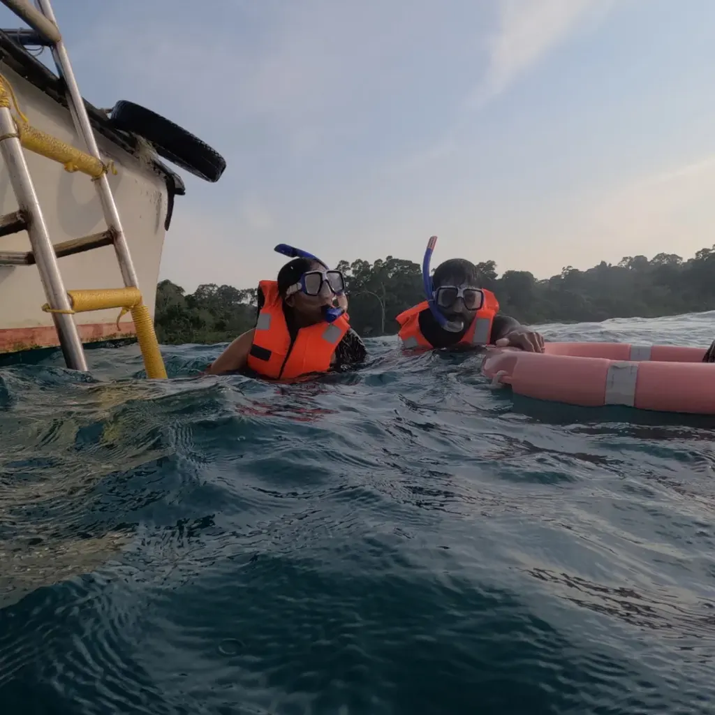 Snorkellers in life jackets beside the boat ladder, snorkelling in Havelock Island