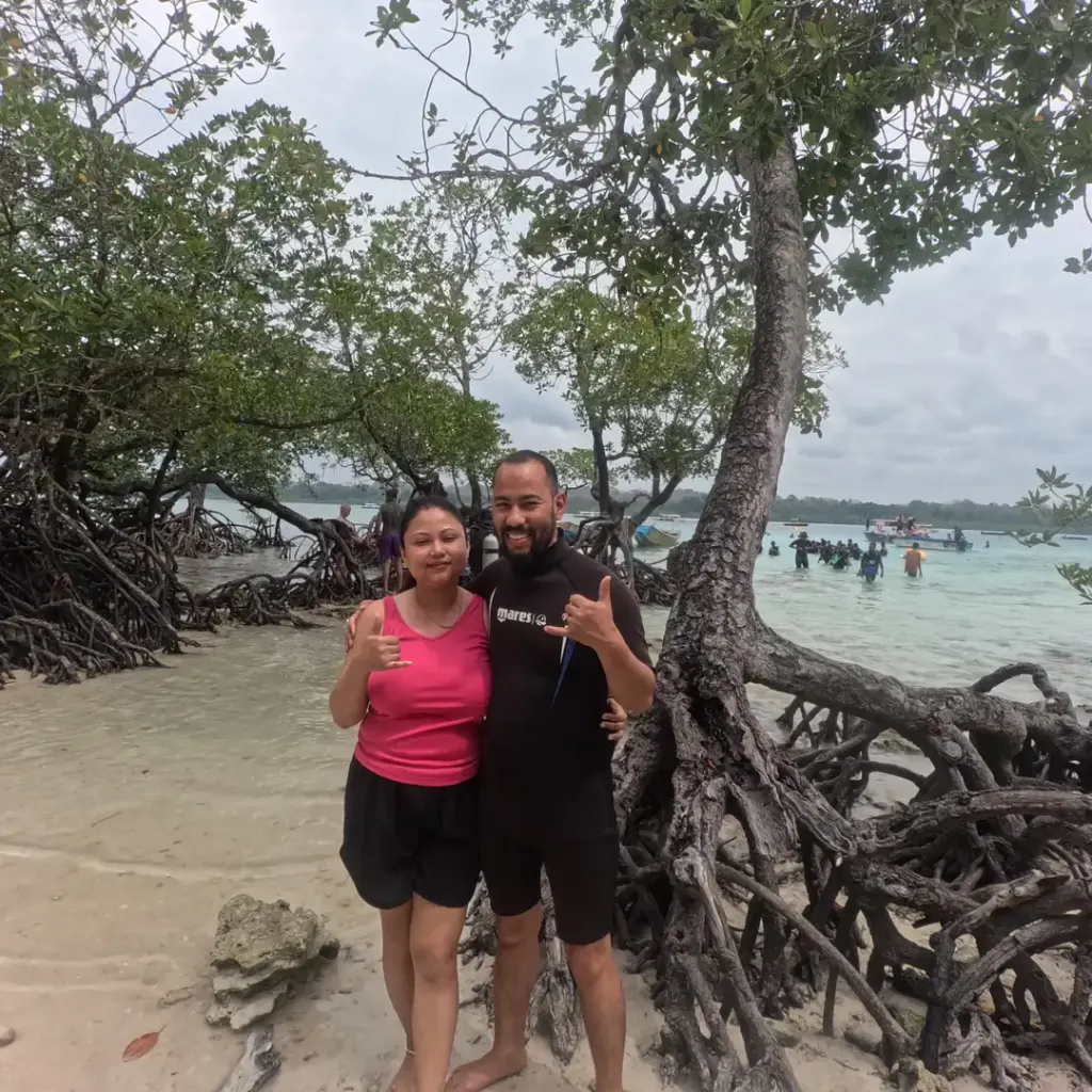 Couple by mangrove roots on the beach, island hopping from Havelock