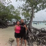 Couple by mangrove roots on the beach, island hopping from Havelock