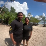 Couple on a sandy beach with trees behind, island hopping from Havelock