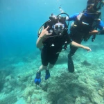 Diver making a shaka with the instructor beside her over the reef, Lighthouse scuba diving, Havelock Island