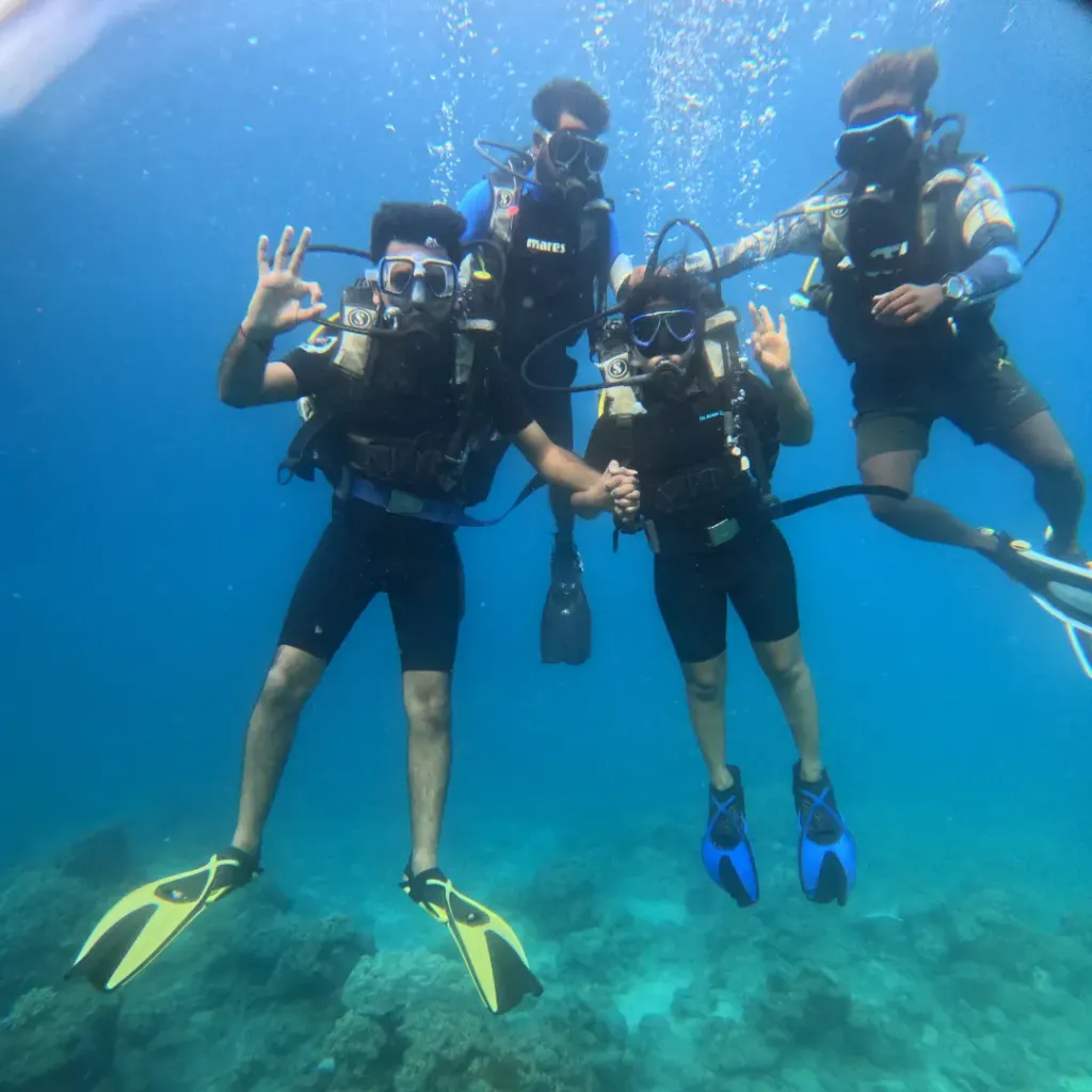 Group of four divers posing together in blue water, Lighthouse scuba diving, Havelock Island