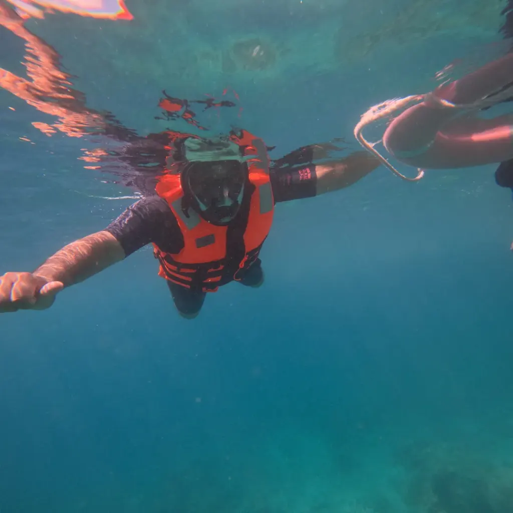 Snorkeller in a life jacket reaching for the float ring, snorkelling in Havelock Island