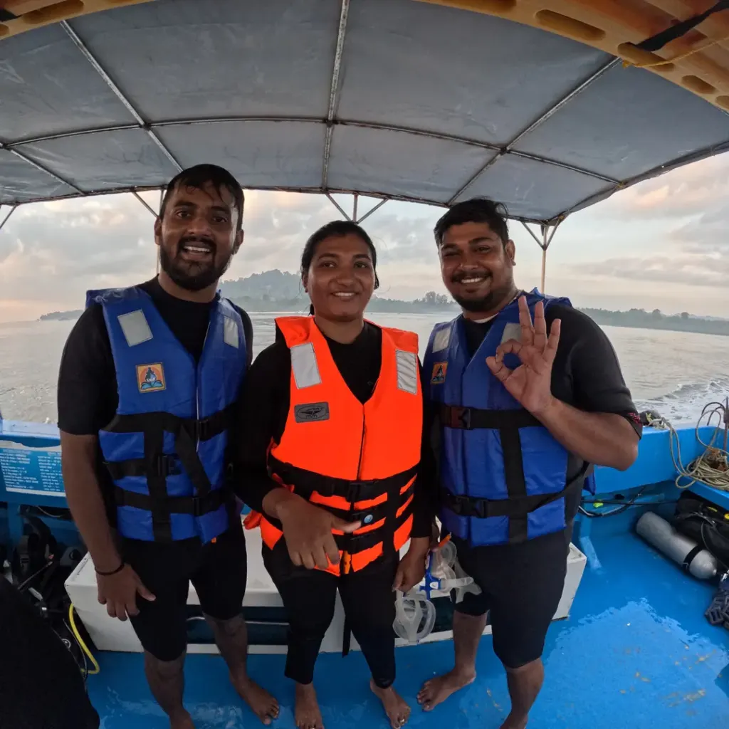 Three guests in life jackets standing on the boat, a boat day trip from Havelock