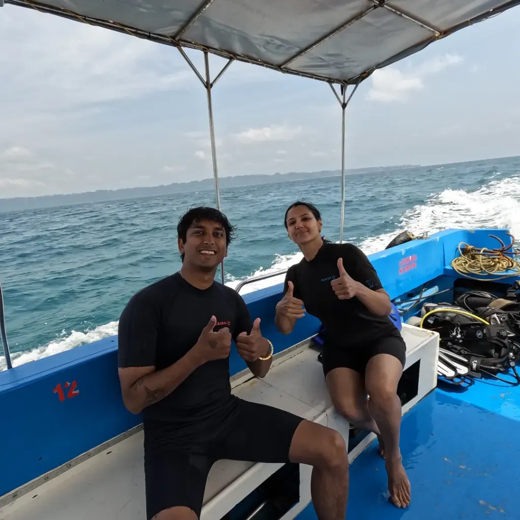 Couple sitting on the boat as it moves across the sea, a boat day trip from Havelock