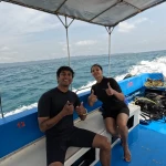 Couple sitting on the boat as it moves across the sea, a boat day trip from Havelock