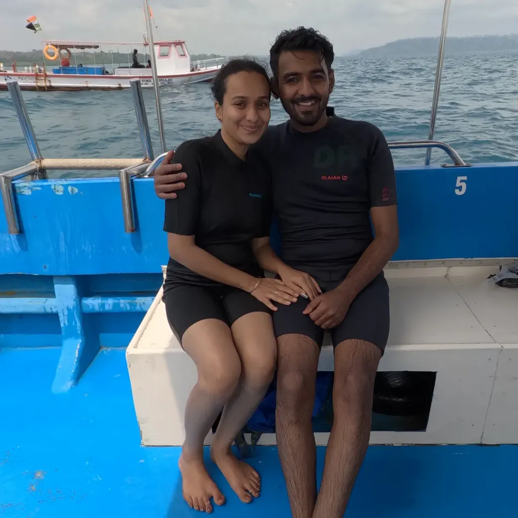 Couple sitting on the side of the boat at sea, a boat day trip from Havelock