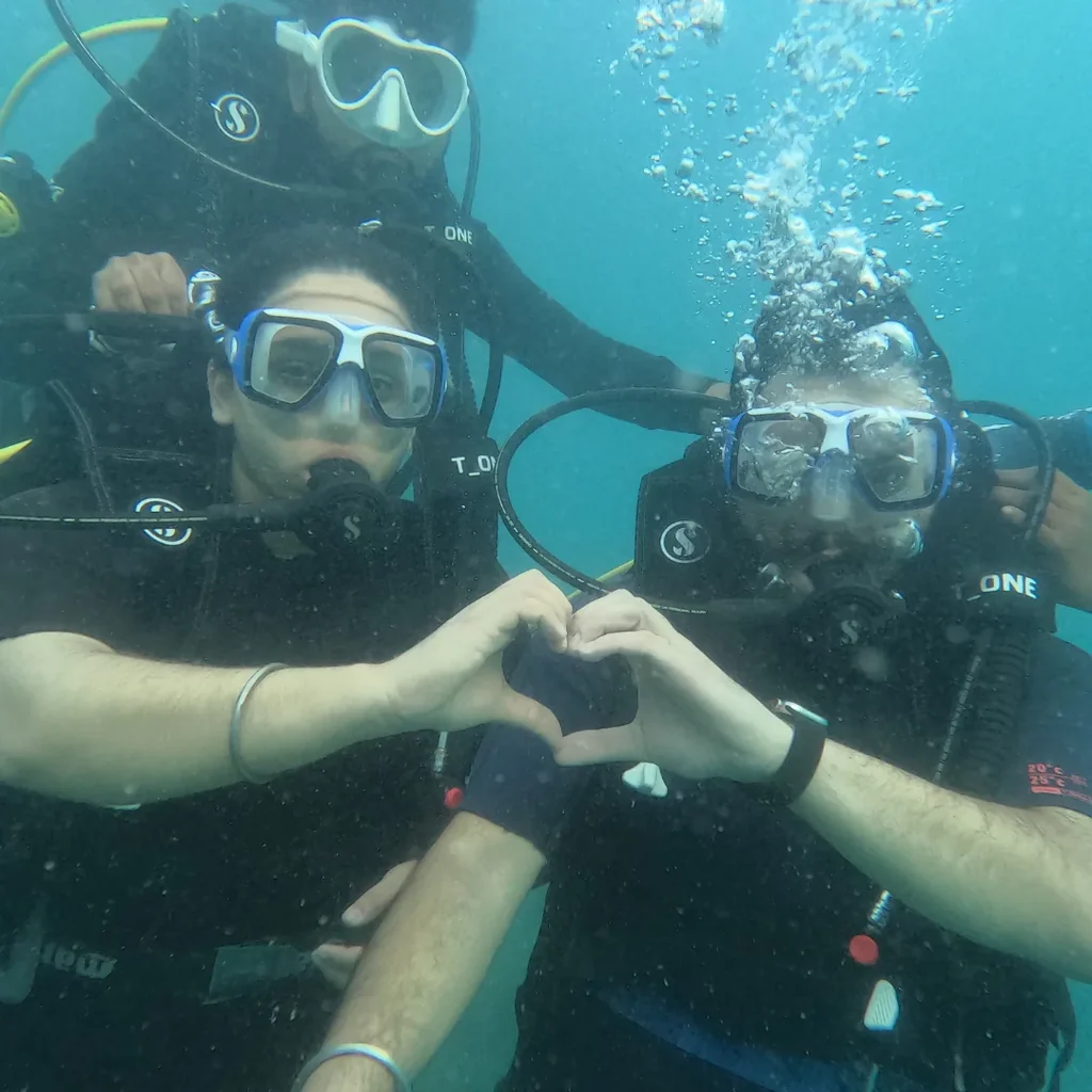 Couple making a heart sign underwater while scuba diving at Nemo Beach, Havelock, Andaman