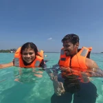 Couple in life jackets in clear shallow water, snorkelling in Havelock Island
