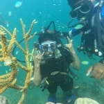 Diver beside orange coral branches with the instructor, scuba diving in Havelock Island