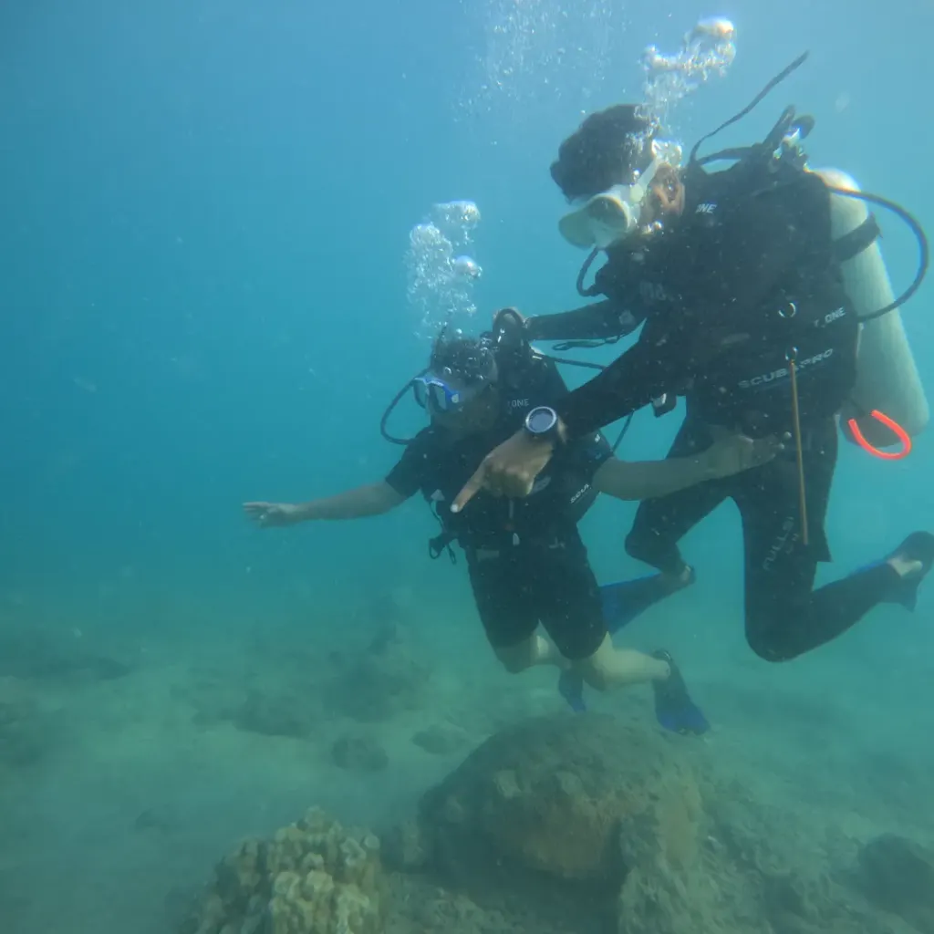 Instructor holding a diver steady over the reef, RAID Master Rescue Diver course in Havelock, Andaman