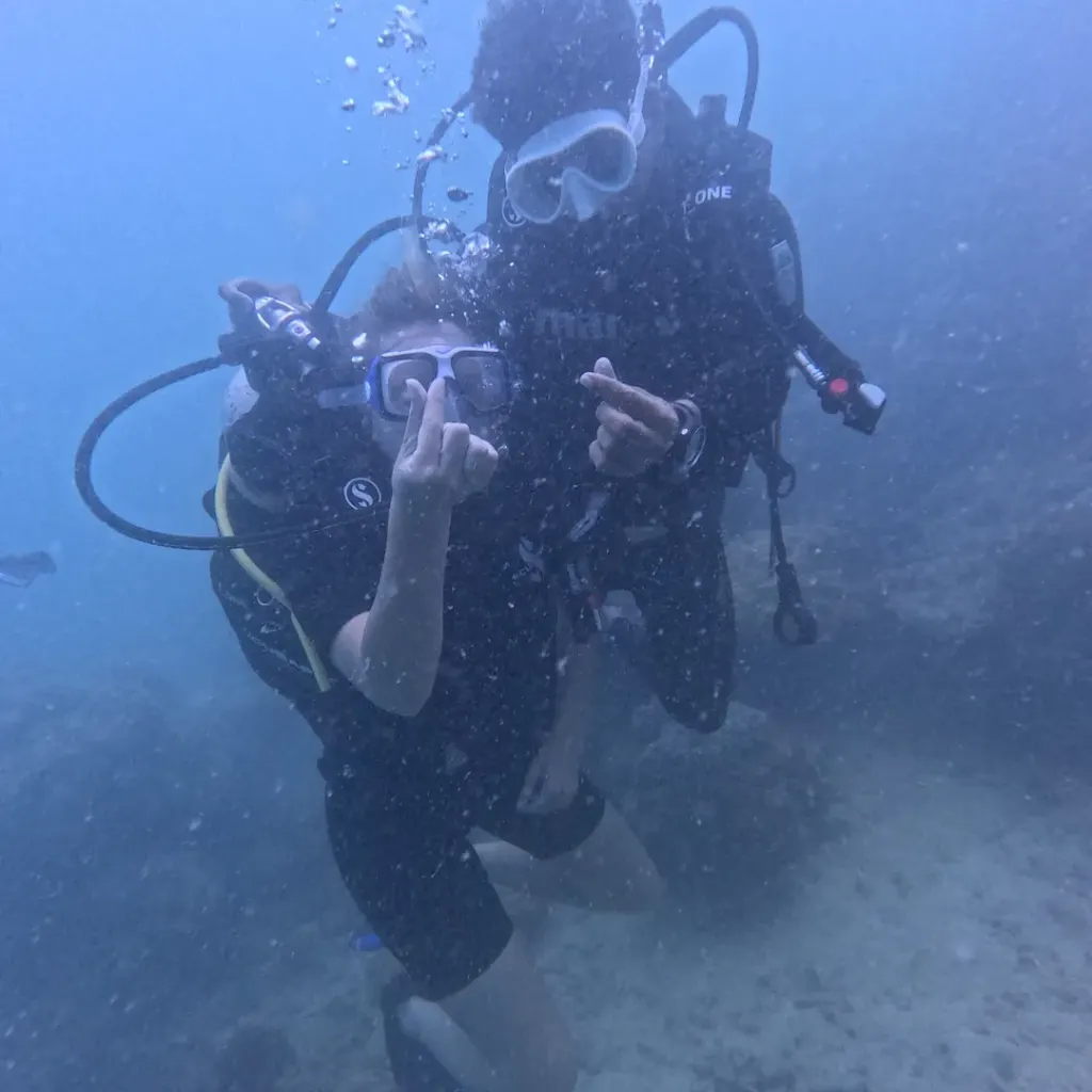 Two divers close together making hand signs, RAID Master Rescue Diver course in Havelock, Andaman