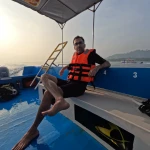 Guest in a life jacket sitting on the boat, RAID Open Water course in Havelock, Andaman