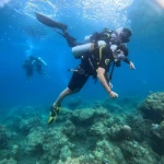 Diver swimming with the instructor holding the tank, Red Pillar scuba diving, Havelock Island