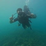 Diver making a peace sign in green water, RAID Master Rescue Diver course in Havelock, Andaman