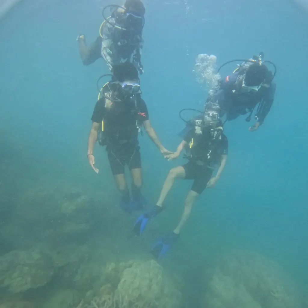 Three divers holding hands under water, RAID Master Rescue Diver course in Havelock, Andaman