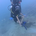 Diver kneeling on the sand doing a skill, scuba refresher in Havelock Island
