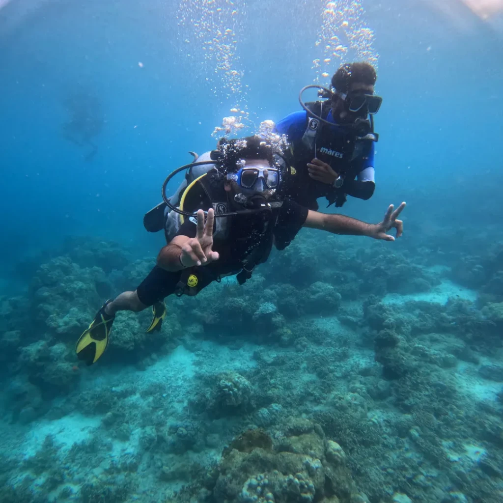 Scuba shore dive in Andaman - diver swimming over the shallow coral reef