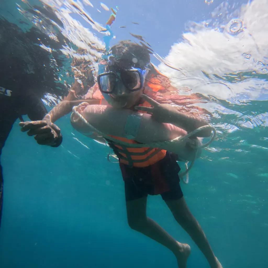 Young snorkeller in a mask and life jacket at the float ring, snorkelling in Havelock Island