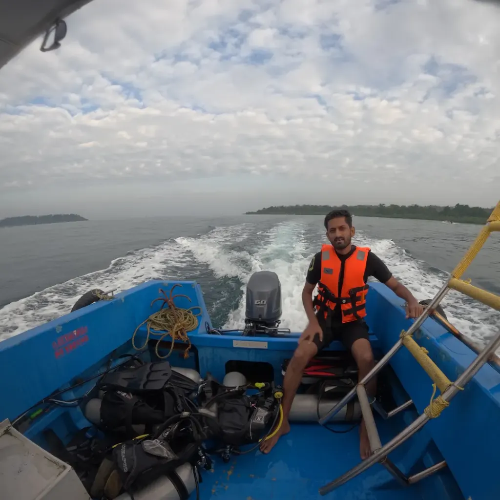 Guest in a life jacket at the back of the boat with the wake behind, a boat trip from Havelock