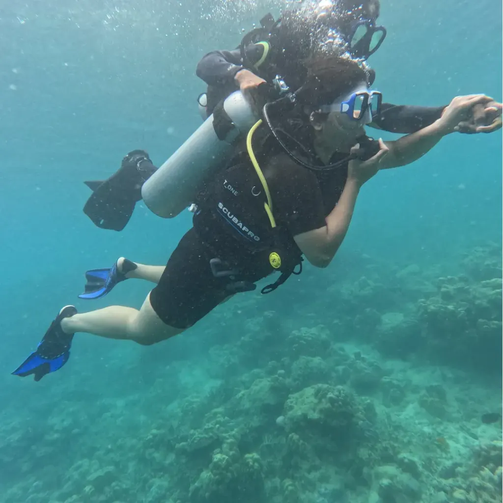 Diver with the instructor holding the tank over the reef, The Slope scuba diving, Havelock Island