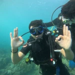 Diver showing two OK signs close to the camera, The Slope scuba diving, Havelock Island