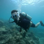 Diver swimming over the reef close to the camera, The Slope scuba diving, Havelock Island