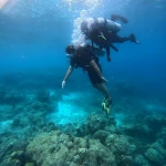 Diver and instructor descending in deep blue water, The Slope scuba diving, Havelock Island