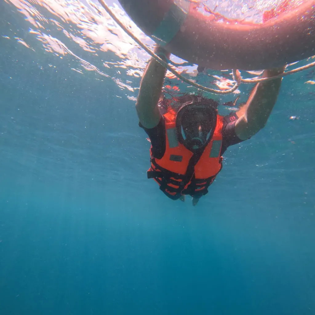 Snorkeller in a full-face mask holding the float ring, snorkelling in Havelock Island