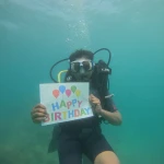 Diver holding a Happy Birthday sign under water, Try Scuba diving in Havelock Island