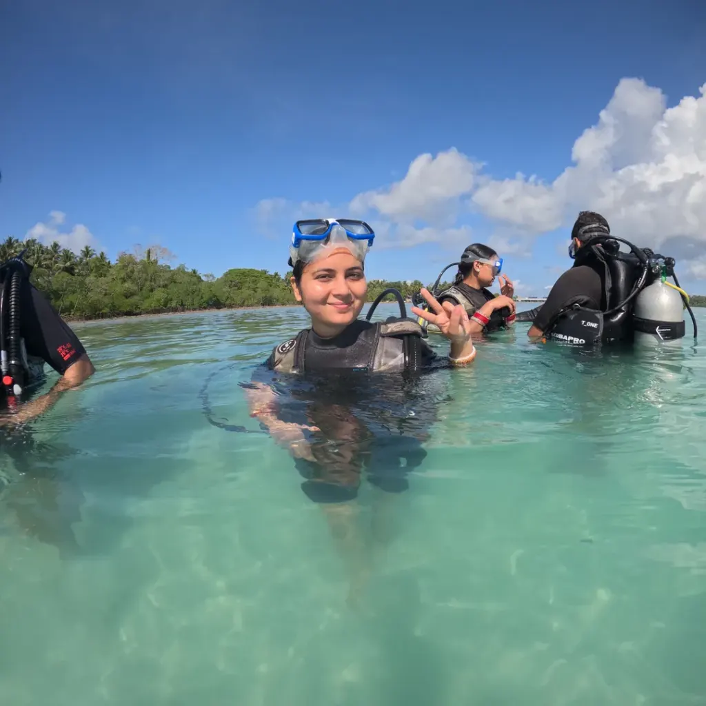 Guest in scuba gear standing in shallow water with others behind, Try Scuba diving in Havelock Island