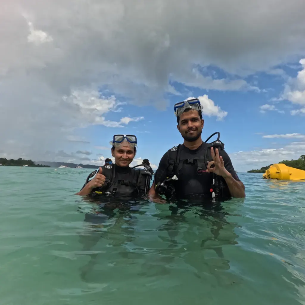 Couple standing in the sea in scuba gear after the dive, Turtle Beach scuba diving, Havelock Island