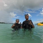 Couple standing in the sea in scuba gear after the dive, Turtle Beach scuba diving, Havelock Island