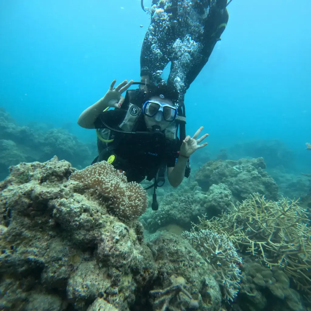 Diver waving over the coral with the instructor above, Turtle Beach scuba diving, Havelock Island