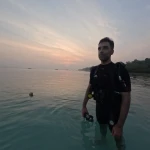 Guest in scuba gear standing in calm water at sunset, Zero to Hero internship in Havelock, Andaman
