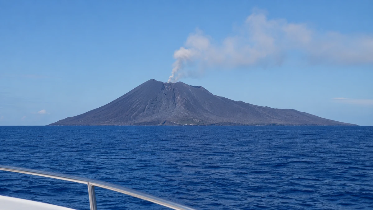 Barren Island active volcano with a steam plume, seen from a boat in the Andaman Sea
